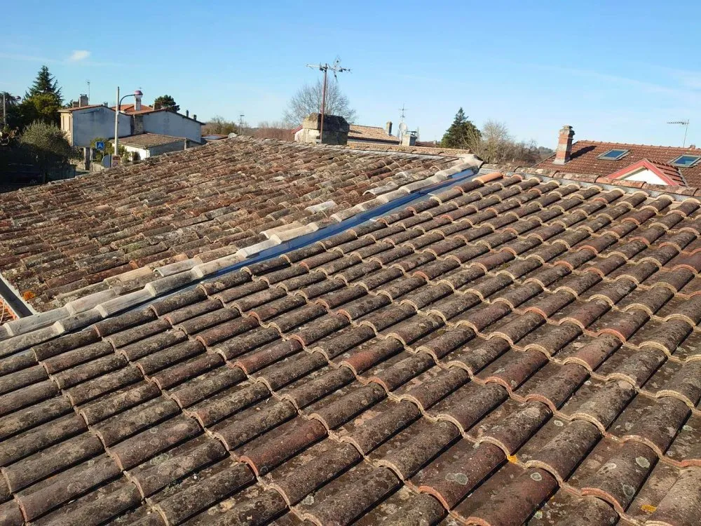 Vue d'ensemble d'un toit en tuiles après nettoyage et entretien, montrant des finitions impeccables. ​​